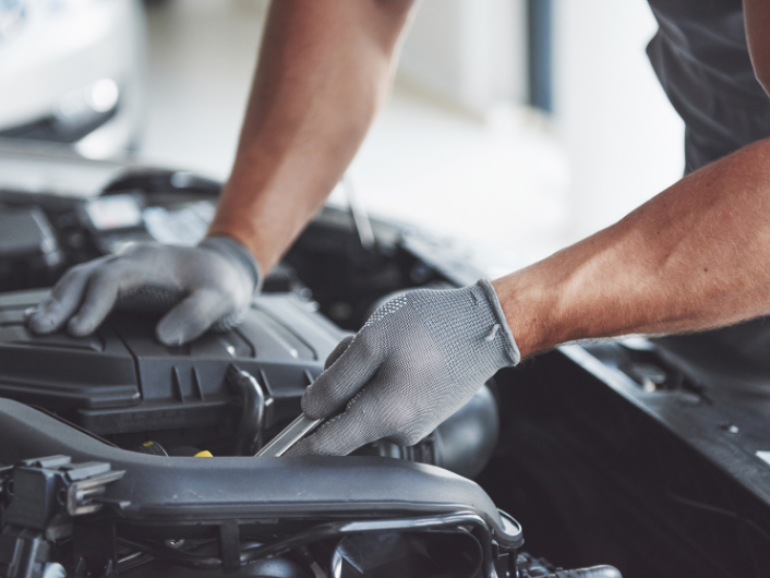 mecanico arreglando coche sector automoción