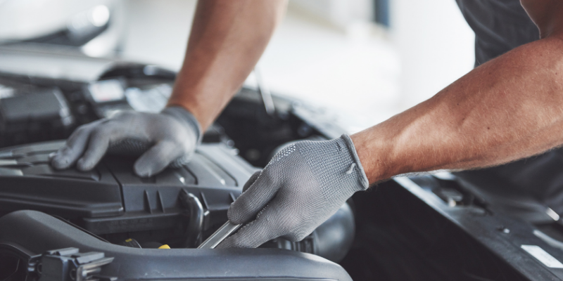 mecanico arreglando coche sector automoción